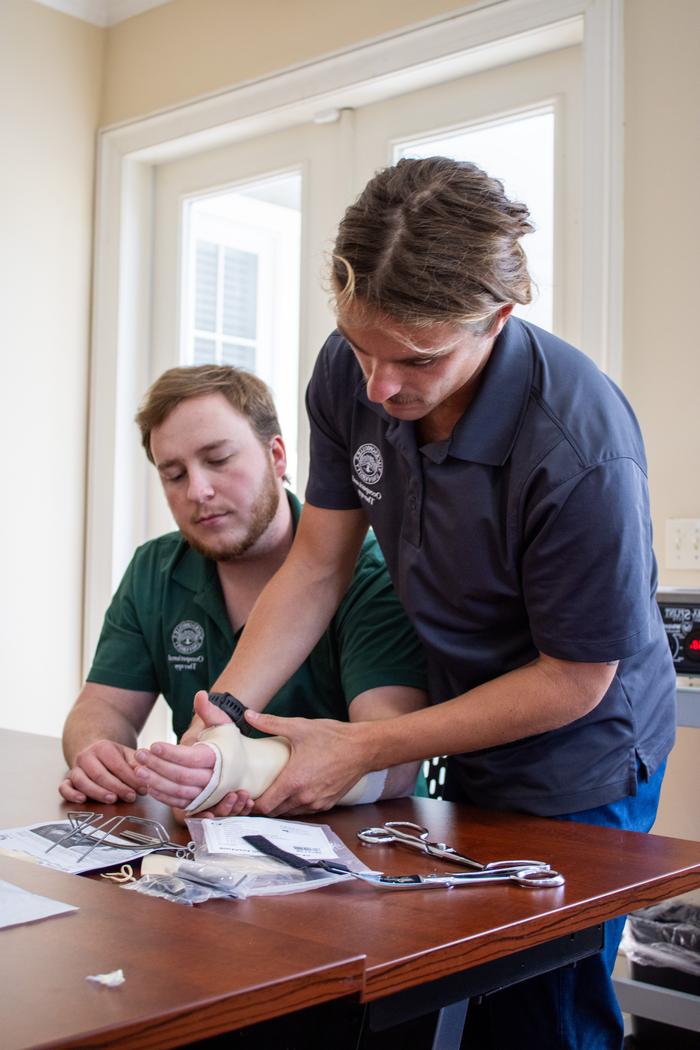 Two Occupational Therapy students demonstrating tools used during sessions