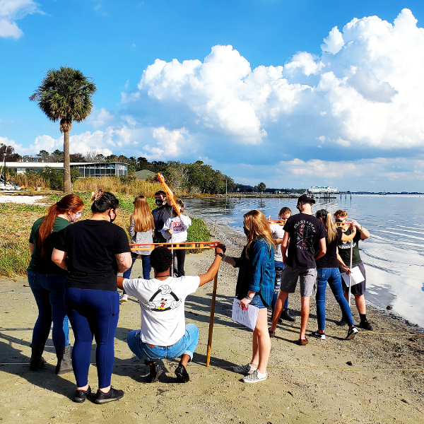 Marine biology students taking measurements on the beach.